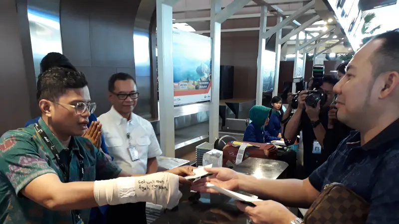 Lengan kanan dibalut gips, Direktur Utama Garuda Indonesia Pahala Nugraha Mansyuri, terlihat melayani calon penumpang maskapainya di Hari Pelanggan Nasional, di Terminal 3 Bandara Internasional Soekarno Hatta, Selasa (4/9/2018).