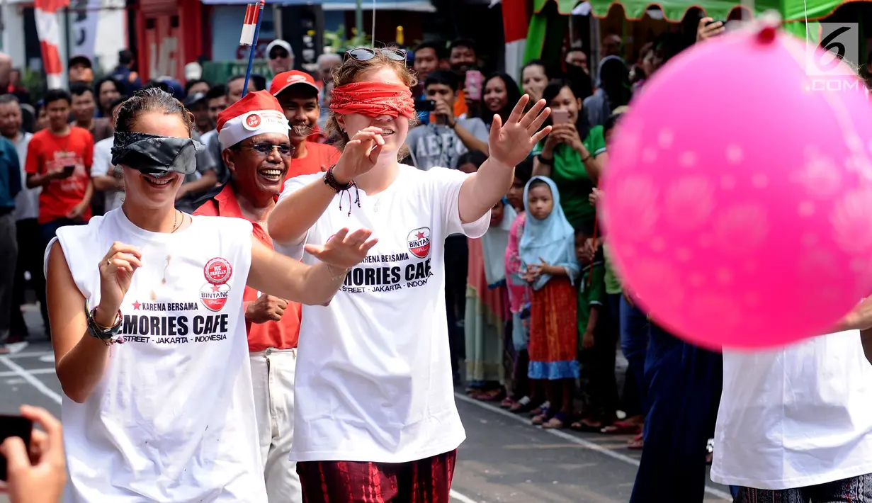 Warga negara asing saat mengikuti lomba pecah balon di kawasan Jalan Jaksa, Jakarta, Kamis (17/8). Lomba diadakan untuk memeriahkan HUT RI ke-72. (Liputan6.com/Helmi Fithriansyah)