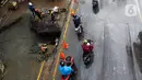 Pengendara melintas dekat perbaikan jalan ambles di Jalan Daan Mogot, Tangerang, Senin (13/1/2020). Amblesnya jalan penghubung ke Jakarta ini diduga karena adanya kebocoran pipa PDAM Tirta Kerta Raharja milik Pemkab Tangerang yang mengikis struktur tanah. (merdeka.com/Magang/Muhammad Fayyadh)