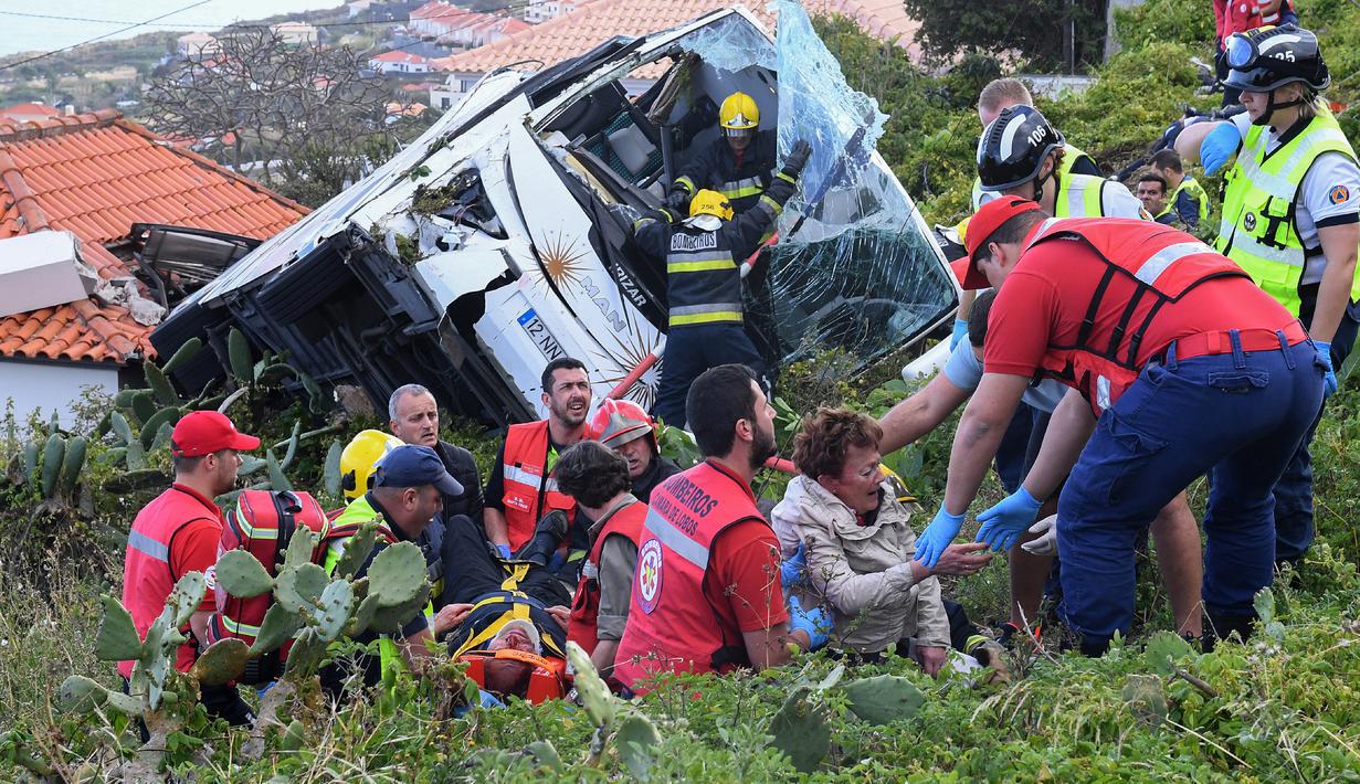 Petugas memberikan pertolongan kepada korban kecelakaan sebuah bus pariwisata di Kota Canico, Pulau Madeira, Portugal, Rabu (17/4). Menurut pejabat perlindungan sipil regional, para turis korban kecelakaan berusia antara 40 hingga 50 tahun. (RUI SILVA / AFP)