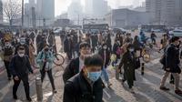 Komuter yang memakai masker berjalan melintasi persimpangan di kawasan pusat bisnis pada hari dengan tingkat polusi udara yang tinggi di Beijing, China, Senin (6/3/2023). Pejabat ekonomi China menyatakan keyakinannya bahwa mereka dapat memenuhi target pertumbuhan tahun ini sekitar 5 persen dengan menghasilkan 12 juta pekerjaan baru dan mendorong pengeluaran konsumen setelah berakhirnya kontrol antivirus yang membuat jutaan orang tetap di rumah. (AP Photo/Mark Schiefelbein)