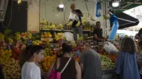 Orang-orang membeli buah dari pasar jalanan di Haifa, Israel, Jumat, 16 Agustus 2024.  (AP Photo/Leo Correa)