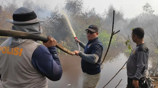 Direktur Reserse Kriminal Khusus Polda Riau Komisaris Besar Gidion Arif Setiawan ikut memadamkan kebakaran lahan agar tak meluas.