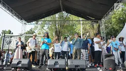 Menteri Kelautan dan Perikanan Susi Pudjiastuti menyanyi bersama personel Slank, Kaka dan Ridho serta musisi Robby Navicula dalam rangkaian pawai Bebas Sampah Plastik di Taman Aspirasi Monas, Jakarta, Minggu (21/7/2019). (Liputan6.com/Immanuel Antonius)