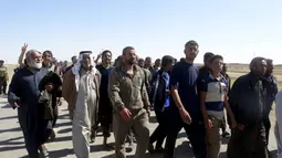 Puluhan warga berjalan saat melarikan diri setelah terjadi pertempuran antara pasukan Irak dan militas ISIS di kota Hit, provinsi Anbar, (5/4/2016). (REUTERS/Stringer)