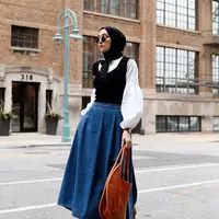 Cocok untuk outfit kerja, padukan blouse putih dengan vest hitam, dan rok jeans a-line ala selebgram Turki Elif Dogan ini. (Instagram/elifd0gan).