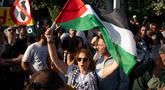 Warga menggelar aksi unjuk rasa menentang pencegatan Armada Solidaritas Global oleh Angkatan Laut Israel di luar Kementerian Luar Negeri, Athena, Yunani, pada 18 Mei 2026. (Aggelos NAKKAS/AFP)