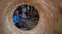 Para pekerja membuat keranjang dari bambu di tempat kerja mereka, Sleman, Yogyakarta pada 9 April 2025. (DEVI RAHMAN/AFP)