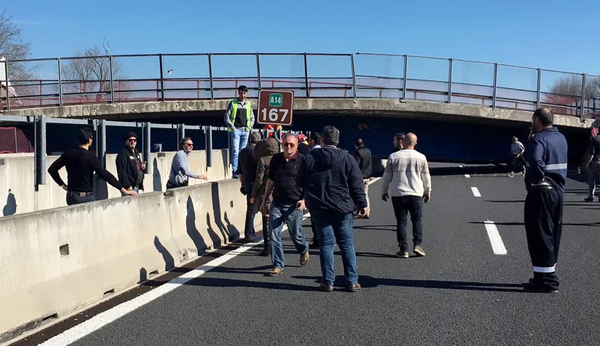 Sejumlah orang mengamati jembatan roboh di Ancona yang melintang di atas ruas jalan tol di wilayah pesisir pantai Italia, Kamis (9/3). Ruas jalan tol Ancona itu ditutup di kedua arahnya untuk demi keselamatan warga. (HO/Polizia di Stato/AFP)