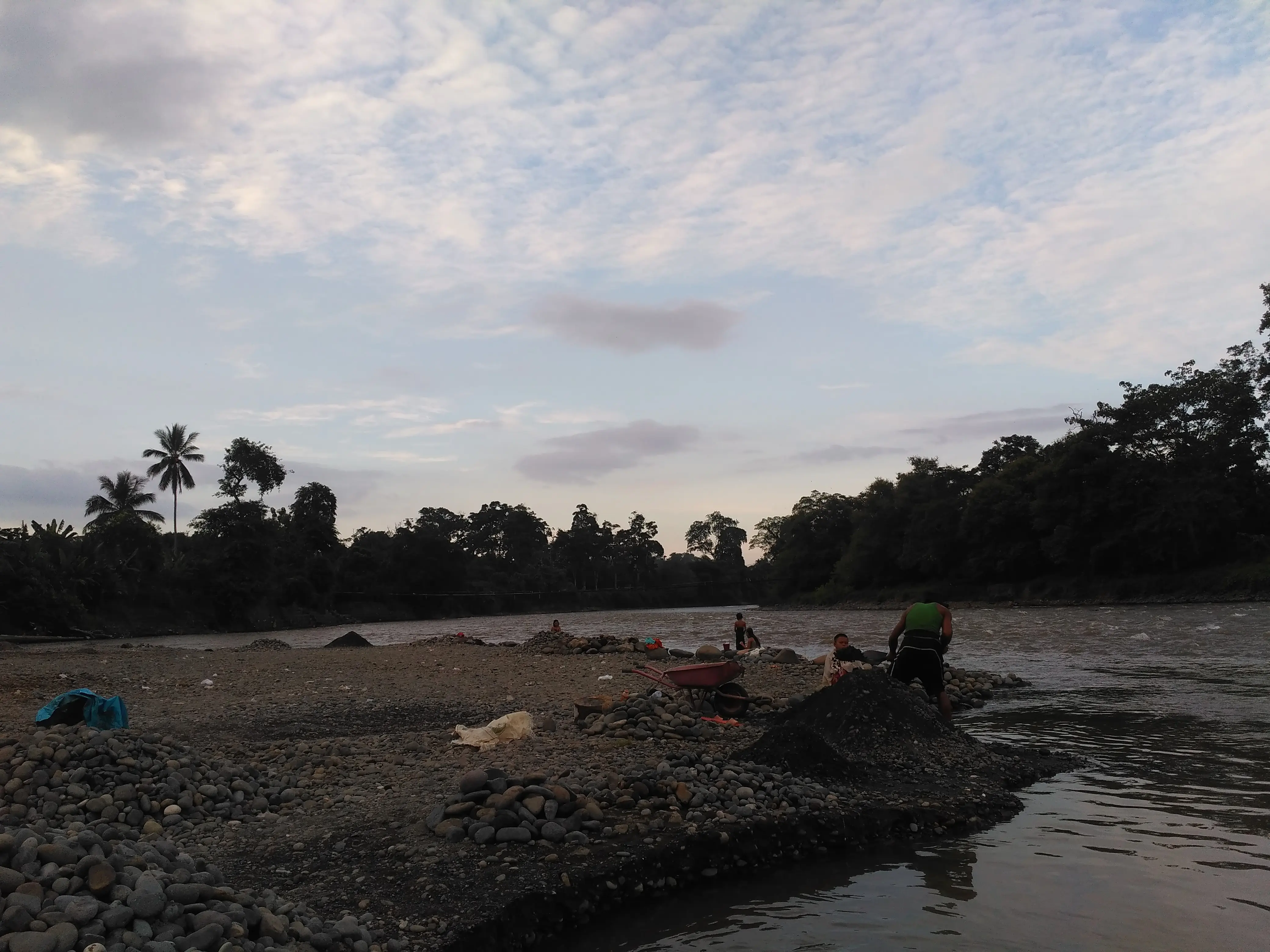 Kegiatan mengumpulkan batu dan tanah di pinggiran Sungai Terusan (Liputan6.com / Nefri Inge)