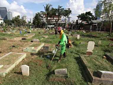 Pekerja membersihkan makam di TPU Karet Bivak, Jakarta, Rabu (4/5). Dinas Pertamanan dan Pemakaman DKI Jakarta menerapkan sistem online pelayanan pemakaman di 77 taman pemakaman umum (TPU). (Liputan6.com/Immanuel Antonius) 