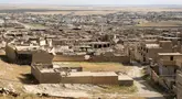 Bangunan-bangunan yang rusak akibat serangan militan Negara Islam (ISIS) tahun 2014 dan pertempuran setelahnya, berdiri di kota Sinjar di provinsi Nineveh, Irak utara, pada 6 Mei 2024. (Safin HAMID / AFP)