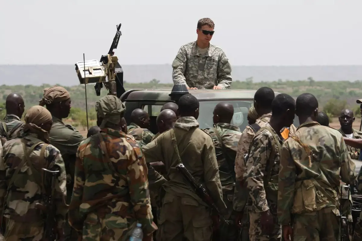 Pada foto tertanggal Mei 2010 ini, seorang personel Pasukan Khusus AS atau US Special Forces - Green Berets (di atas mobil) tengah memberikan arahan kepada tentara Mali. Pasukan AS dikerahkan untuk membantu tentara setempat menumpas teroris di Afrika (AP)