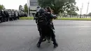 Polisi Anti Huru Hara AS menangkap seorang wanita yang melakukan unjuk rasa di dekat markas Kepolisian Rouge Baton di Baton Rouge, Louisiana, AS (9/7). Unjuk rasa tersebut sebagai aksi protes terkait kebrutalan polisi di AS. (REUTERS / Jonathan Bachman)