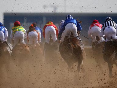 Para joki berlomba dalam lomba pacuan kuda Dubai Kahalya Classic yang menjadi bagian dalam Dubai World Cup di lintasan pacuan kuda Meydan, UEA, (26/3/2016). (AFP/Marwan Naamani)