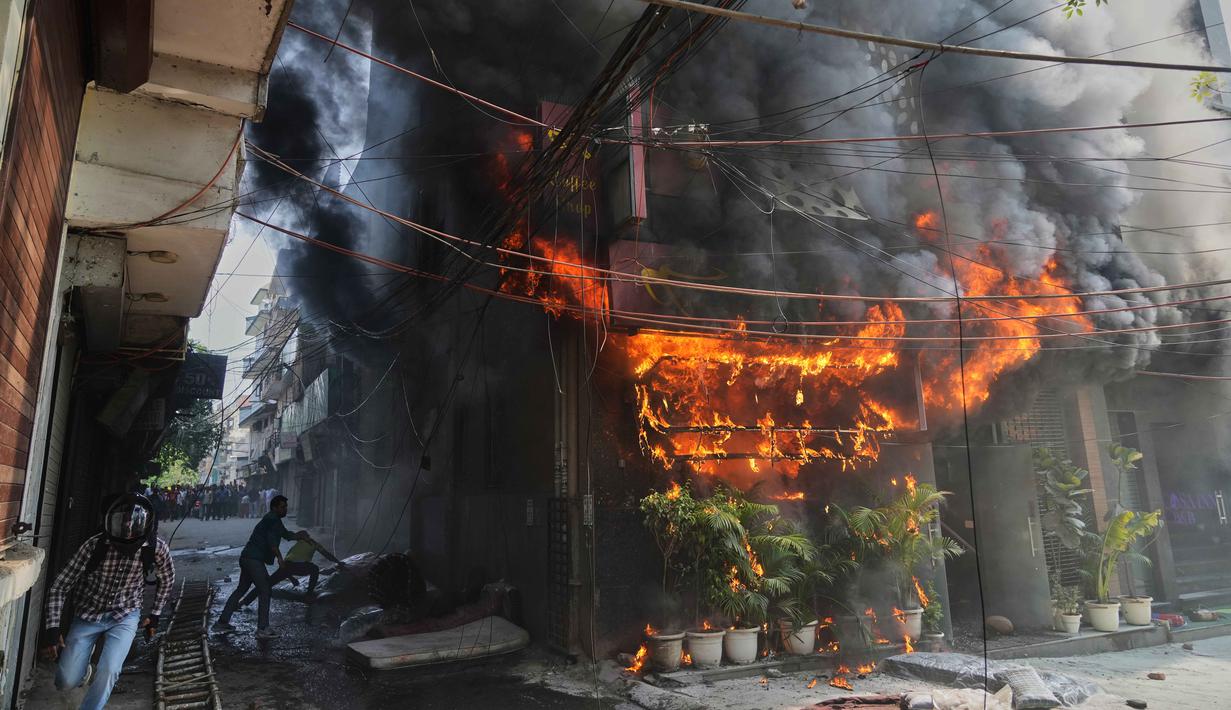 Masyarakat setempat berupaya memadamkan api yang membakar sebuah hotel di New Delhi, India, Rabu 3 Juni 2026. (AP Photo/Manish Swarup)