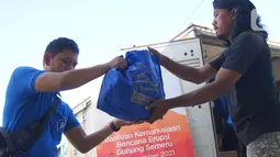 Relawan QNET mendistribusikan bantuan makanan kepada warga terdampak erupsi Gunung Semeru di Kabupaten Lumajang, Jawa Timur (25/12/2021). Bantuan makanan dari QNET melalui RYTHM Foundation juga ditujukan kepada warga yang tidak tertampung di tenda-tenda pengungsian. (Liputan6.com/HO/QNET)