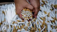 Sejumlah batang rokok ilegal diperlihatkan petugas saat rilis rokok ilegal di Kantor Direktorat Jenderal Bea Cukai, Jakarta, Jumat (30/9). Rokok ilegal ini diproduksi oleh mesin dengan total produksi 1500 batang per menit. (Liputan6.com/Faizal Fanani)