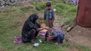 Khalida, perempuan pengembara Kashmir Bakarwal mencuci rambut putrinya di luar kamp sementara di pinggiran Srinagar, India, 31 Agustus 2020. Suku Bakarwals adalah kaum penggembala nomaden di Jammu Kashmir, yang berpindah-pindah mencari padang rumput yang baik untuk ternak mereka. (AP Photo/Dar Yasin