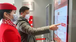 Wisatawan membeli tiket dengan mesin penjual tiket otomatis di Shanghai Oriental Pearl Tower, Shanghai, China, Kamis (12/3/2020). Shanghai Oriental Pearl Tower, Shanghai Jinmao Tower, dan Shanghai Tower sudah menerima wisatawan mulai 12 Maret 2020. (Xinhua/Ding Ting)
