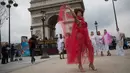 Seorang model ukuran plus bergaya saat tampil di depan Triump Arch di Paris, Prancis (4/1). Acara ini bertujuan mempromosikan keragaman yang bertema "All Sizes Catwalk". (AFP/Thomas Samson)