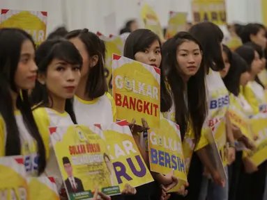 Sejumlah gadis muda cantik membawa poster saat penutupan Musyawarah Nasional Luar Biasa (Munaslub) partai Golkar di Jakarta, Rabu (20/12). (Liputan6.com/Faizal Fanani)
