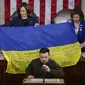 Presiden Ukraina Volodymyr Zelensky berpidato di pertemuan gabungan Kongres di Capitol Hill di Washington, Rabu, 21 Desember 2022. Ia menyerahkan bendera Ukraina yang ditandatangani oleh pasukan garis depan di Bakhmut. (AP Photo/Jacquelyn Martin)