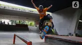 Salah satu remaja saat bermain papan seluncur atau skateboard di taman seluncur (skatepark) dan lintasan sepeda BMX di kolong jalan layang tol dalam kota, Slipi, Jakarta, Selasa (13/5/2025). (Liputan6.com/Angga Yuniar)