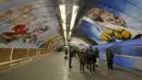 Sejumlah penumpang menunggu kereta di stasiun metro bawah tanah kota  yang dipenuhi dengan mural di Kyiv, Ukraina, Rabu, (29/1/2020). (AP Photo / Efrem Lukatsky)