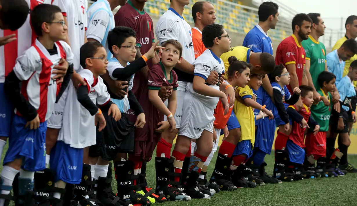 Anak berkebutuhan khusus dan pesepakbola Brasil bersiap bermain bola saat acara "World Boots" di Neymar Institute, Brasil, 7 Juni 2015. Acara tersebut diadakan pesepakbola Brasil Neymar untuk anak-anak berkebutuhan khusus. (REUTERS/Paulo Whitaker)