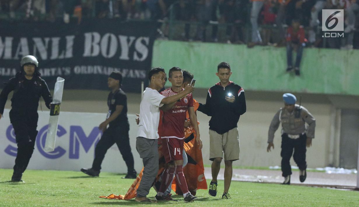 Suporter tim Macan Kemayoran berswafoto dengan pemain Persija, Ismed Sofyan usai laga melawan PSMS di laga pertama semifinal Piala Presiden 2018 di Stadion Manahan, Solo, Jawa Tengah, Sabtu (10/2). (Liputan6.com/Helmi Fithriansyah)