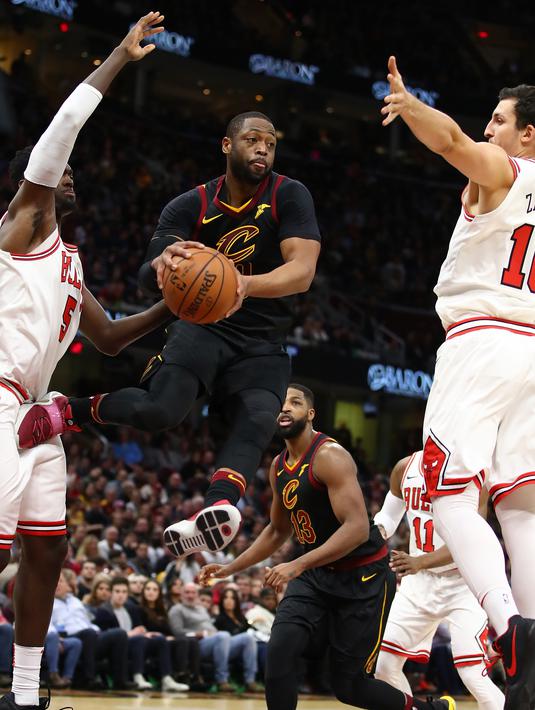 Aksi Dwyane Wade #9 melompat sambil memberikan umpan saat dikepung dua pemain  Chicago Bulls pada laga NBA basketball game di Quicken Loans Arena, Cleveland, (21/12/2017). Cleveland menang 115-112. (Gregory Shamus/Getty Images/AFP)