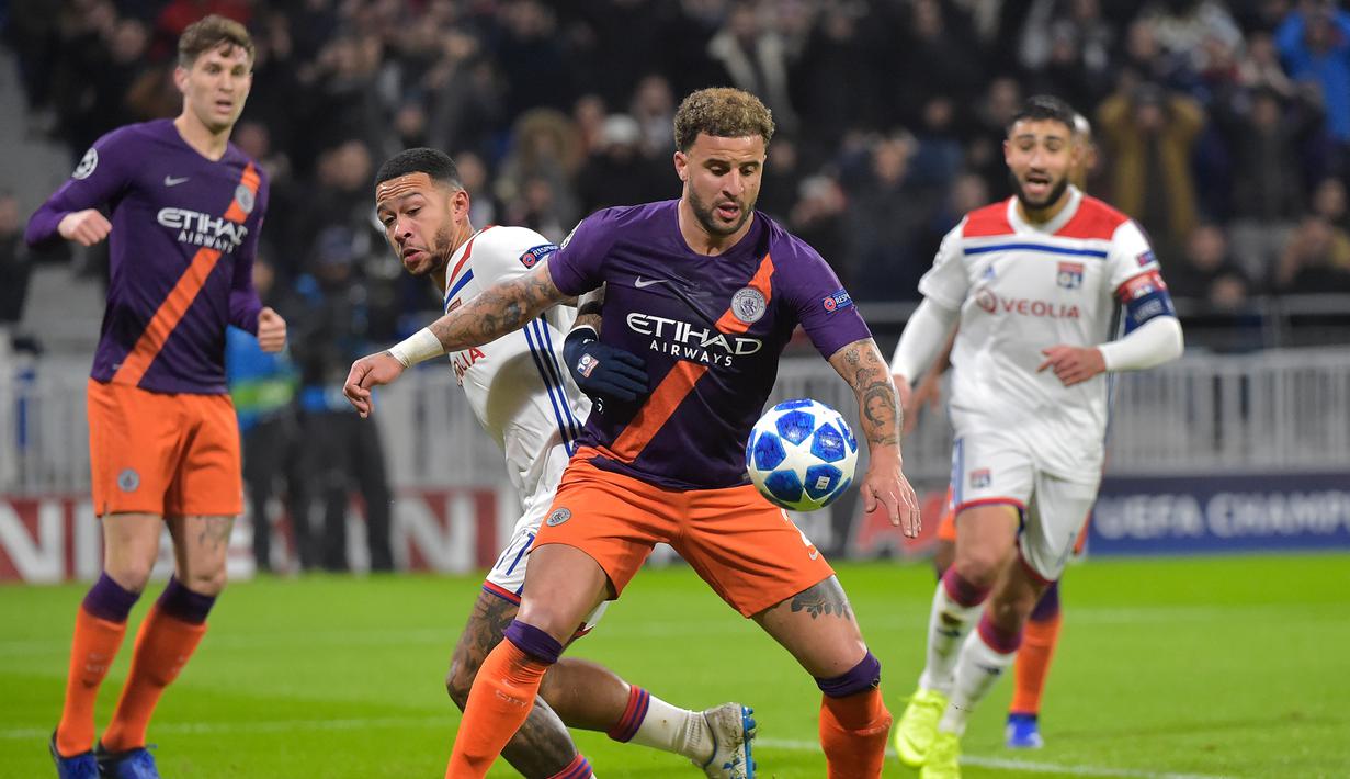 Pemain Man City, Kyle Walker menghadang pemain Lyon, Memphis Depay pada laga lanjutan liga champions yang berlangsung di stadion Parc Olympique Lyonnais, Prancis, Rabu (28/11). Lyon bermain imbang 1-1 kontra Manchester City. (AFP/Roman Lafabregue)