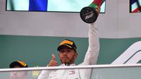 Pebalap tim Mercedes, Lewis Hamilton, melakukan selebrasi usai menjadi juara pada Grand Prix (GP) Formula Satu, di Sirkuit Kota Baku, Baku, Azerbaijan, Minggu (29/4/2018). (AFP/Andrej Isakovic)
