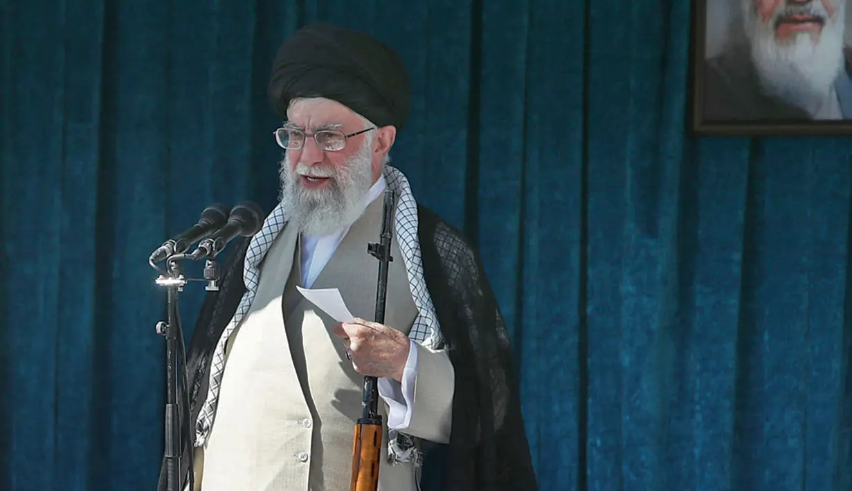 Pemimpin tertinggi Iran Ayatollah Ali Khamenei membawa senapan saat menyampaikan kutbah Idul Fitri di Imam Khomeini Mausoleum, Teheran, Rabu (5/6/2019). Khamenei mengecam Bahrain yang bersedia menjadi tuan rumah untuk menyosialisasikan Deal of the Century. (HO/Iranian Supreme Leader's Website/AFP)