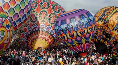 Para peserta bersiap menerbangkan balon udara dalam festival balon udara tradisional di Wonosobo, Jawa Tengah pada 11 April 2024. (DEVI RAHMAN/AFP)