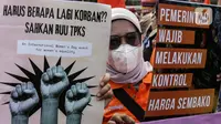 Buruh perempuan memegang poster saat menggelar aksi di depan gedung DPR RI, Jakarta, Selasa (8/3/2022). Mereka menuntut dibatalkannya Omnibus Law UU Cipta Kerja dan mendesak agar RUU Tindak Pidana Kekerasan Seksual (TPKS) segera disahkan oleh DPR RI. (Liputan6.com/Johan Tallo)