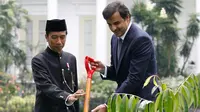 Presiden Joko Widodo (kanan) saat menemani Emir Qatar Syekh Tamim bin Hamad Al Thani menanam pohon eboni di Istana Bogor, Jawa Barat, Rabu (18/10). Pohon eboni merupakan pohon endemik atau kayu hitam Sulawesi. (AFP Photo/Pool/Beawiharta)