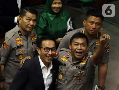 Komjen Pol Idham Azis (kanan) mengacungkan jari kepada wartawan setelah ditetapkan sebagai Kapolri dalam rapat paripurna di Kompleks Parlemen, Jakarta,  Kamis (31/10/2019). DPR menyetujui Idham Aziz menjadi Kapolri menggantikan Jenderal Polisi (Purn) Tito Karnavian. (Liputan6.com/JohanTallo)