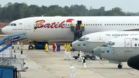 Sejumlah Warga Negara Indonesia (WNI) yang dievakuasi dari Wuhan, China keluar dari pesawat Batik Air Airbus 330-300CEO di bandara internasional Hang Nadim, Batam, Minggu (2/2/2020). Para WNI langsung ke luar pesawat untuk selanjutnya menuju Natuna, Kepulauan Riau. (AFP/Ricky Prakoso)