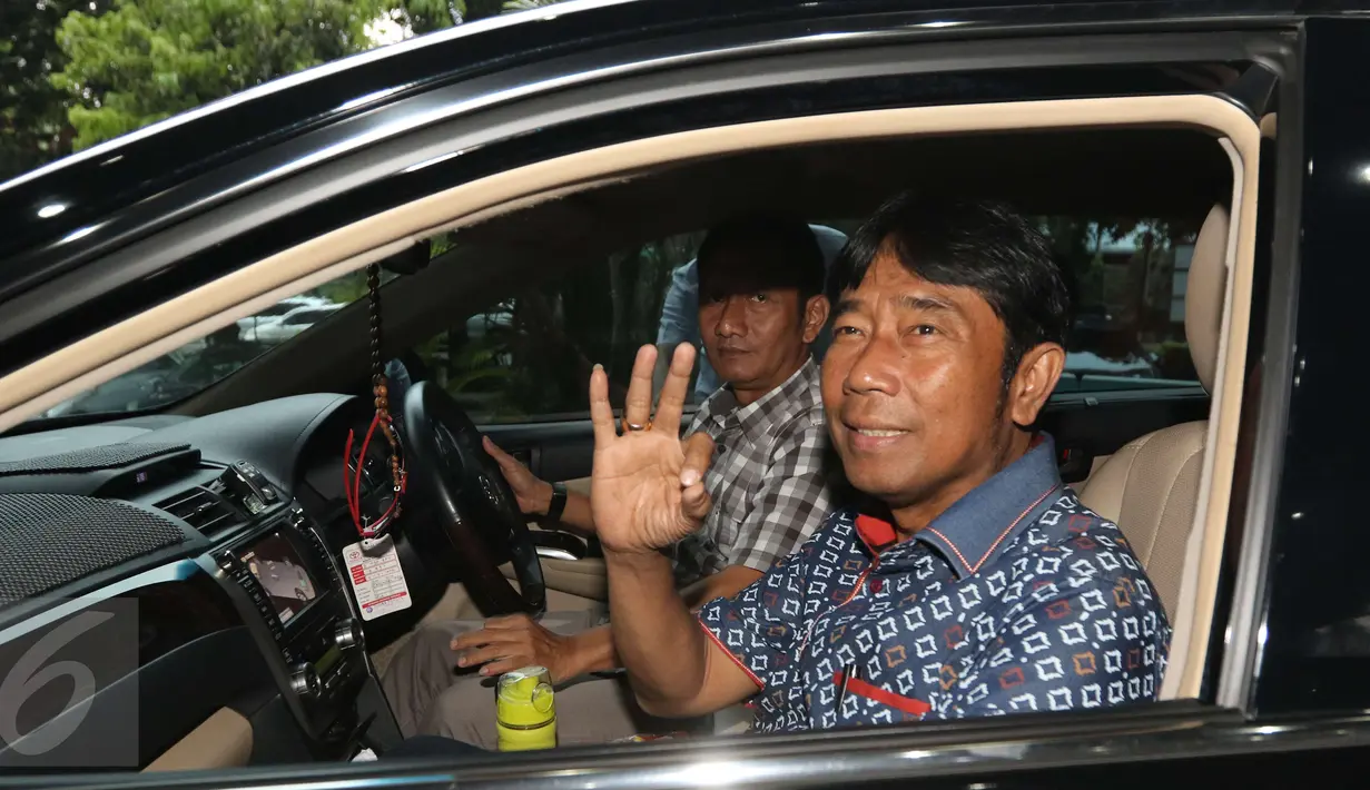 Haji Lulung memperlihatkan salam tiga jari usai diperiksa Bareskrim di Ombudsman, Jakarta, Rabu (12/4). Lulung mengaku tidak terlibat pembahasan proyek pengerjaan revitalisasi gedung Teater Kesenian Jakarta. (Liputan6.com/Helmi Afandi) 