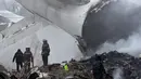 Petugas mengevakuasi bangkai pesawat kargo Turki yang jatuh di daerah perumahan di Bishkek, Kyrgyzstan (16/1). Sebuah pesawat kargo milik Turkish Airlines jatuh dekat Bandara Manas, Kyrgyztan. (AP Photo/Vladimir Voronin)