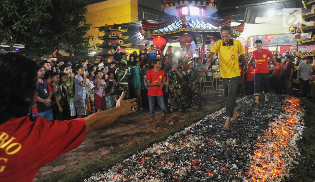 Warga melakukan atraksi Tahwe atau menginjak bara api di Hok Tek Bio Cibinong, Bogor, Sabtu (17/3). Tradisi injak bara tersebut dalam rangka rangkaian Sejit (ulang tahun) Kongco Ho Tek Tjeng Sin atau Dewa Bumi. (Merdeka.com/Arie Basuki)
