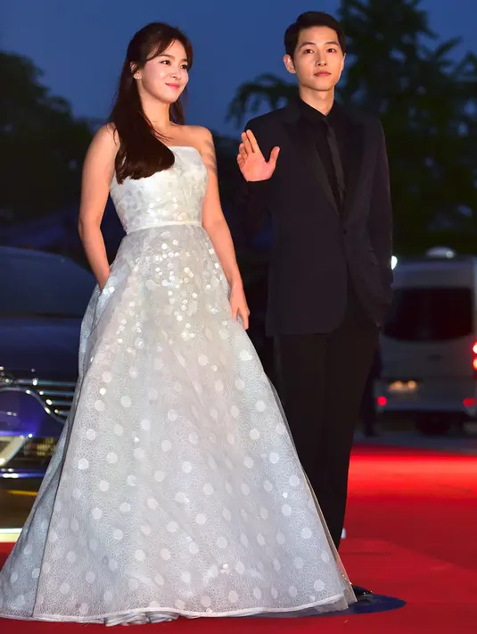 Song Joong Ki dan Song Hye Kyo melambaikan tangan ketika berpose di karpet merah The 52nd Baeksang Art Awards di Seoul, 3 Juni 2016. Song Song Couple dipertemukan sebagai lawan main dalam drama Korea, Descendants of The Sun. (JUNG YEON-JE/AFP)