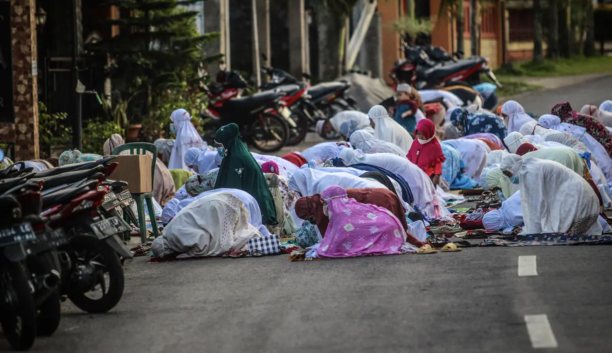 Umat ​​muslim melaksanakan salat Idul Adha di luar sebuah masjid di Ungaran, Jawa Tengah, Selasa (20/7/2021). Umat muslim Indonesia melewati Hari Raya Idul Adha tahun ini di tengah gelombang virus corona COVID-19. (WF Sihardian/AFP)