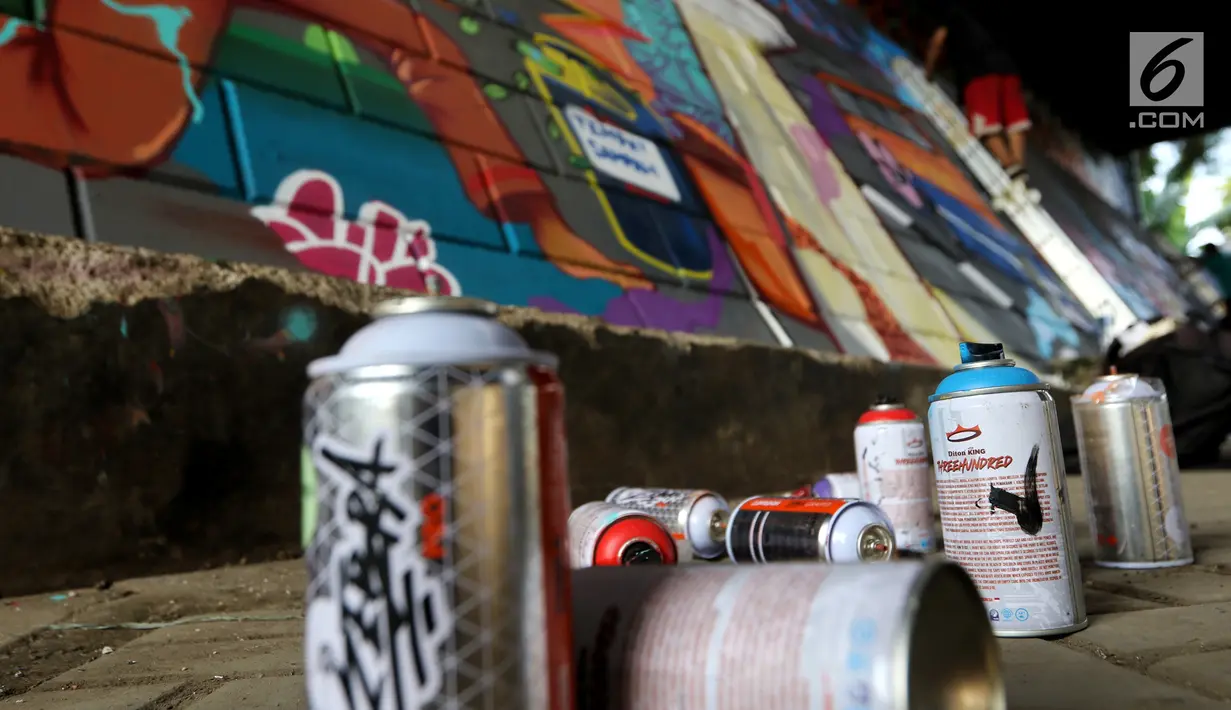 Seniman dari Komunitas mural dan Gravity menyelesaikan gambar di Kolong Tol, Jakarta, Rabu (19/6/2019). Pembuatan Mural Gravity tersebut bermaksud untuk membuat lingkungan sekitar menjadi indah dan elok dipandang mata. (Liputan6.com/Johan Tallo)