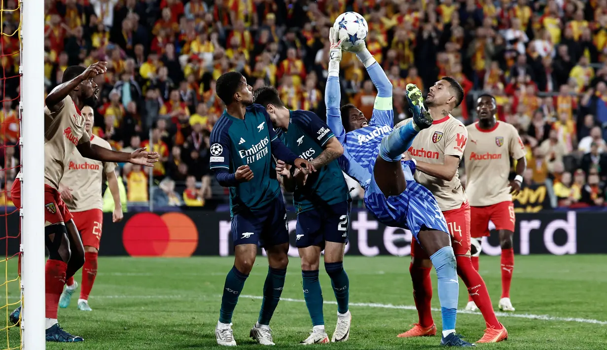 Kiper RC Lens, Brice Samba, mengankap bola saat melawan Arsenal pada laga Liga Champions di Stade Bollaert-Delelis, Rabu (4/10/2023). Arsenal sempat unggul lebih dahulu berkat gol Gabriel Jesus. (AFP/Sameer Al-Doumy)