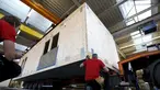 Pegawai bangunan saat merekonstruksi sebuah rumah prefabrikasi untuk pengungsi di perusahaan konstruksi Bauer Holzsysteme, Jerman, (7/12).  Rumah prefabrikasi ini dapat diangkut dan dipindahkan dengan menggunakan truk angkut. (REUTERS/Michaela Rehle)