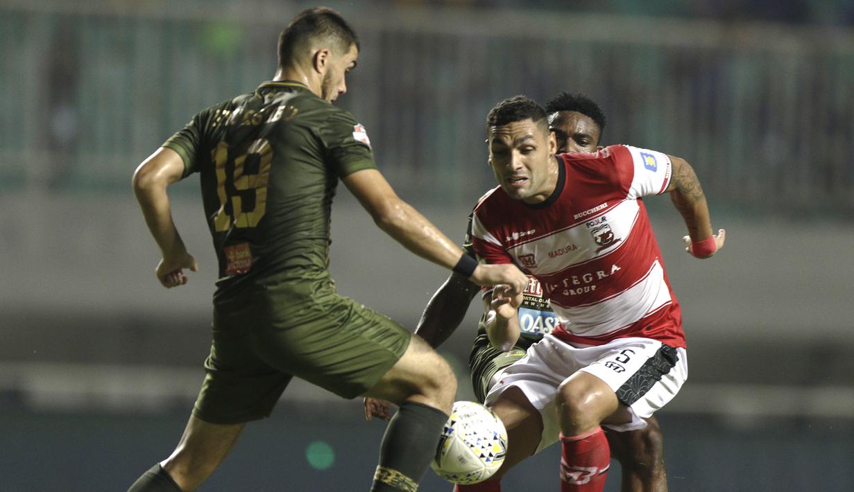 Bek Madura United, Jaimerson Silva, berebut bola dengan pemain Tira Persikabo pada laga Shopee Liga 1 di Stadion Pakansari, Bogor (12/7). Tira bermain imbang 2-2 atas Madura. (Bola.com/Yoppy Renato)