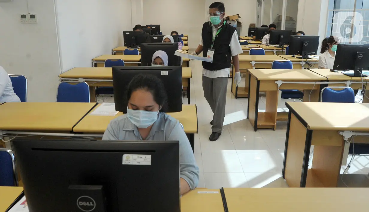 Petugas membagikan kertas pada peserta saat Ujian Tulis Berbasis Komputer (UTBK) gelombang pertama di Kampus Fakultas Teknik UPN Veteran Jakarta, Cinere, Depok, Jawa Barat, Minggu (5/7/2020). UTBK 2020 dibagi dua gelombang, pertama 5-14 Juli 2020 dan kedua 20-29 Juli 2020. (merdeka.com/Arie Basuki)